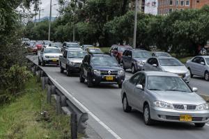 Carros se movilizan por una calle en Bogotá